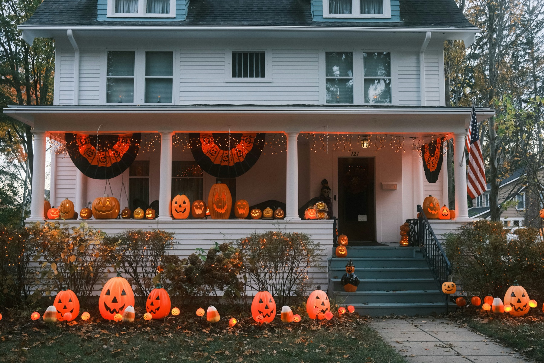 A house with a porch lined with glowing jack-o'-lanterns at dusk